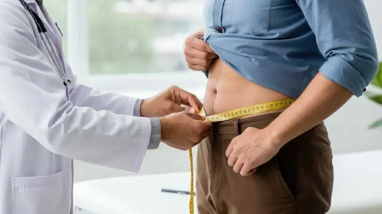 Doctor measuring a male patient's waistline during a medical weight loss in Sugar Land, TX